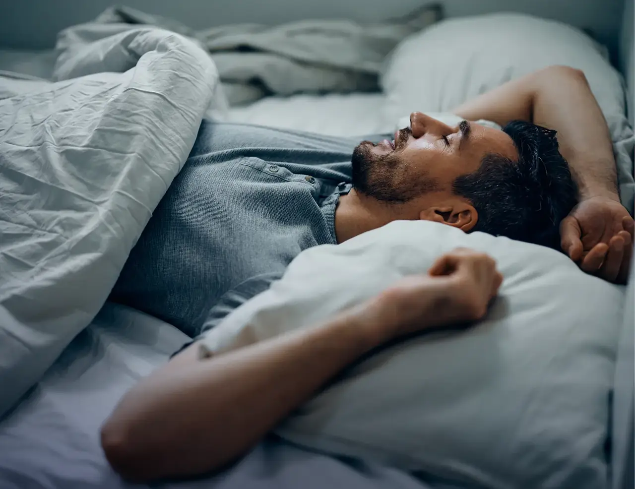 A man lying awake in bed at night